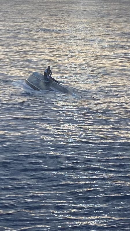 مردی در دریای بین فلوریدا و میامی به بدنه یک قایق واژگون شده چسبیده است