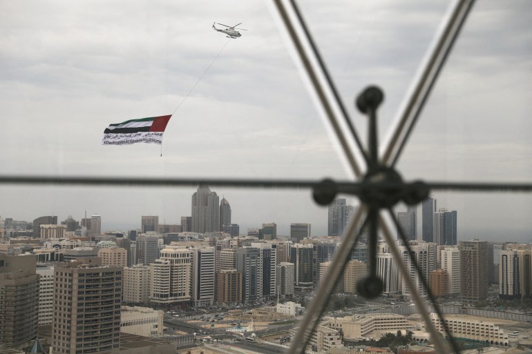 A helicopter flies over the downtown skyline of Abu Dhabi