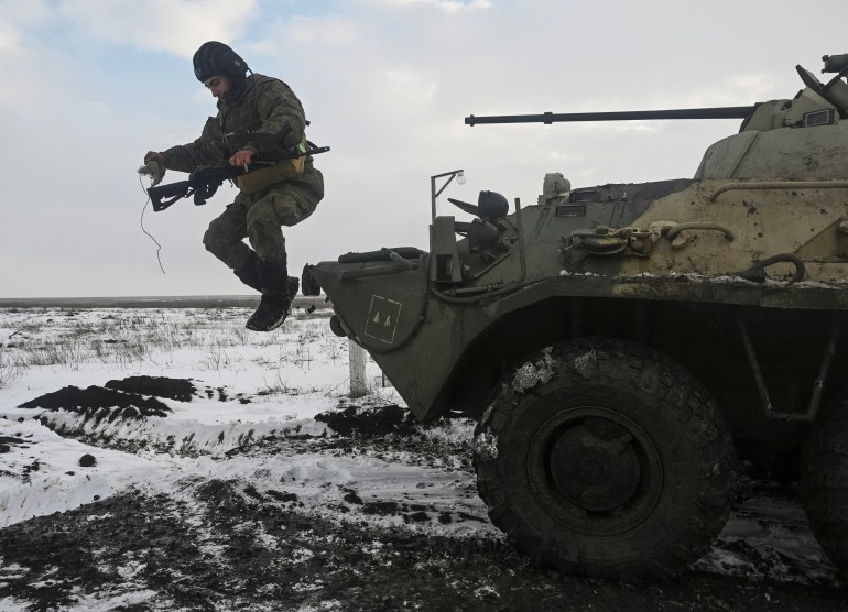 A Russian army service member jumps off an armoured personnel carrier BTR-82 during drills at the Kuzminsky range in the southern Rostov region