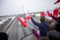 Supporters cheer on the convoy on a highway overpass