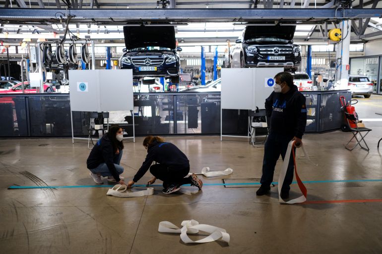 Volunteers prepare a polling station at an auto repair shop for the snap elections, in Lisbon, Portugal, January 29, 2022. [Pedro Nunes/Reuters]