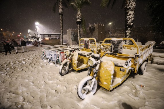 Vehicles are covered with snow around Damascus Gate after snowfall in East Jerusalem on January 26, 2022.