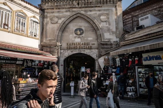 Pedestrians walk past an entrance to the Grand Bazaar in Istanbul, Turkey