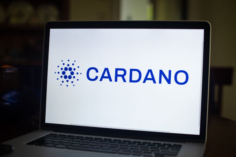 The Cardano logo on a laptop computer