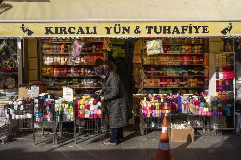 Bir alışverişçi Eskişehir, Türkiye'de bir tuhafiyede yüne göz atıyor
