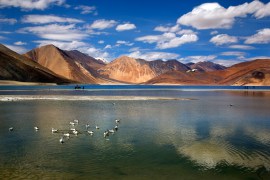 Indian tourist rides on a horse back at the Pangong Lake high up in Ladakh