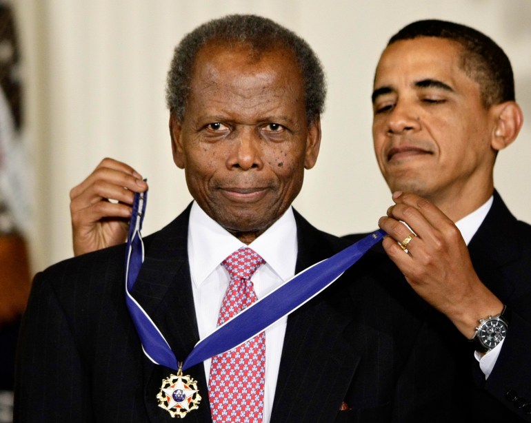 President Barack Obama putting the 2009 Presidential Medal of Freedom around Sidney Poitier's neck