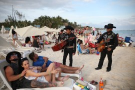 Musicians approach a group of tourists in Playa del Carmen, Mexico