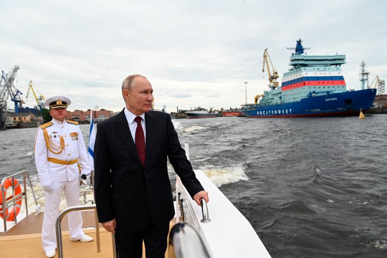 Russia's President Vladimir Putin stands on a military ship