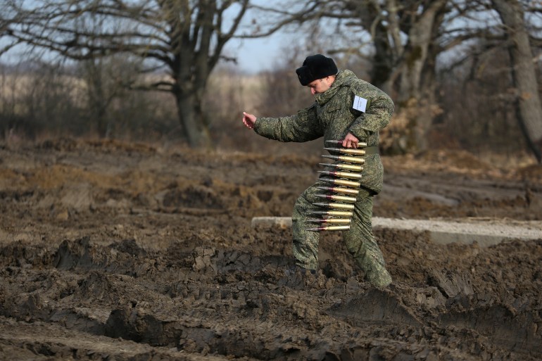 A Russian serviceman carries an ammunition during a military drills at Molkino training ground in the Krasnodar region, Russia
