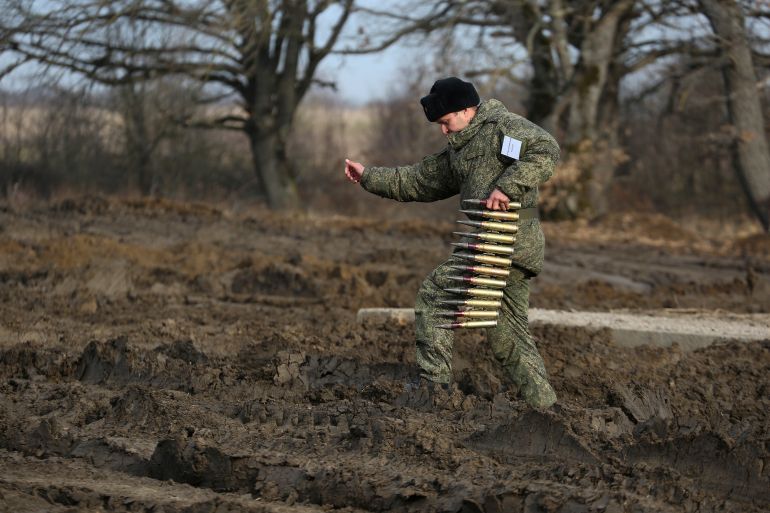 A Russian serviceman carries an ammunition during a military drills at Molkino training ground in the Krasnodar region, Russia