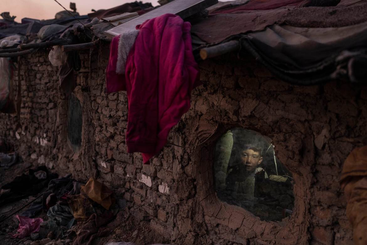 A child looks out a window of his home in Kabul