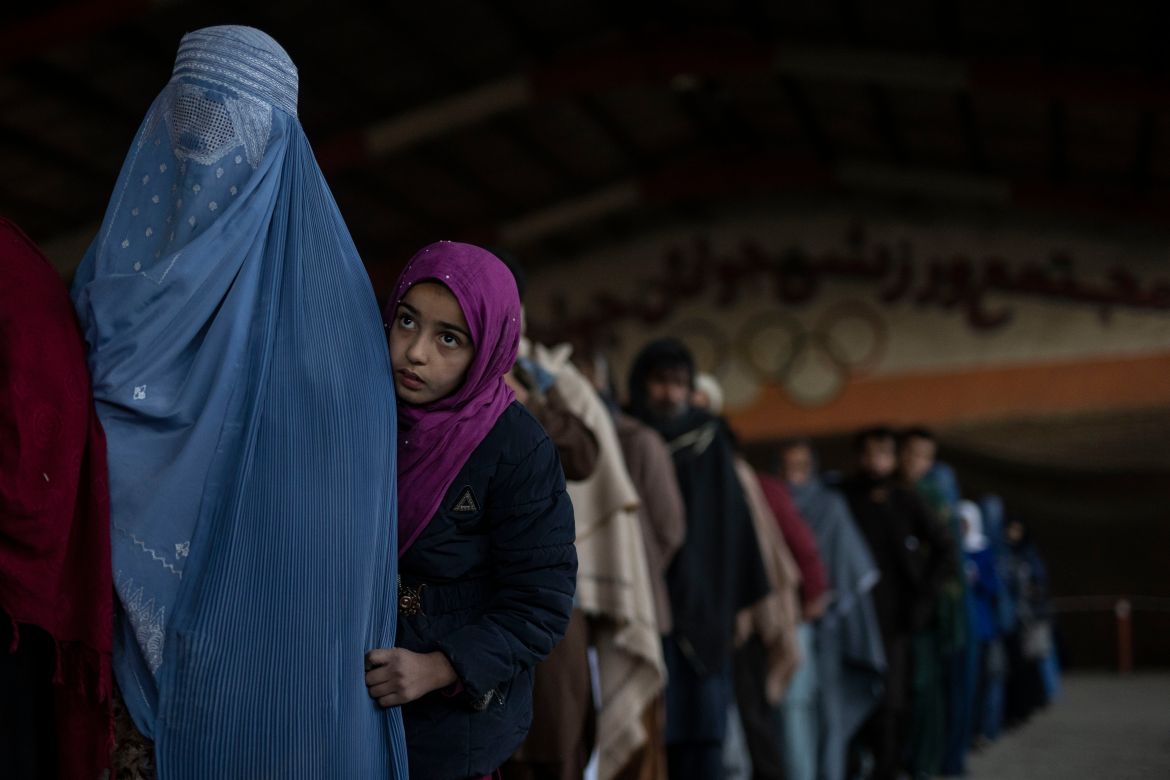 Women queue to receive cash at a money distribution site organised by the WFP in Kabul