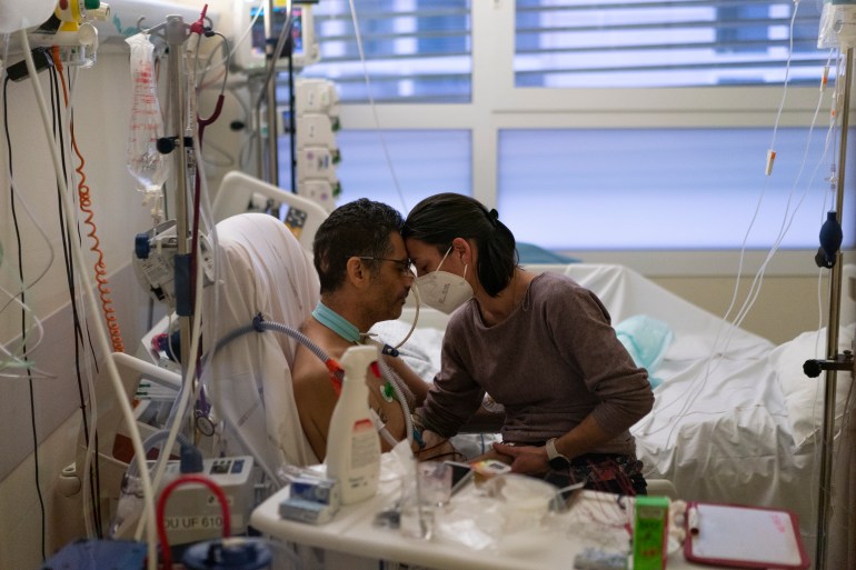 Amelie and Ludo Khayat hold each other during a visit at the COVID-19 intensive care unit of the la Timone hospital in Marseille, southern France, Thursday, December 23, 2021.