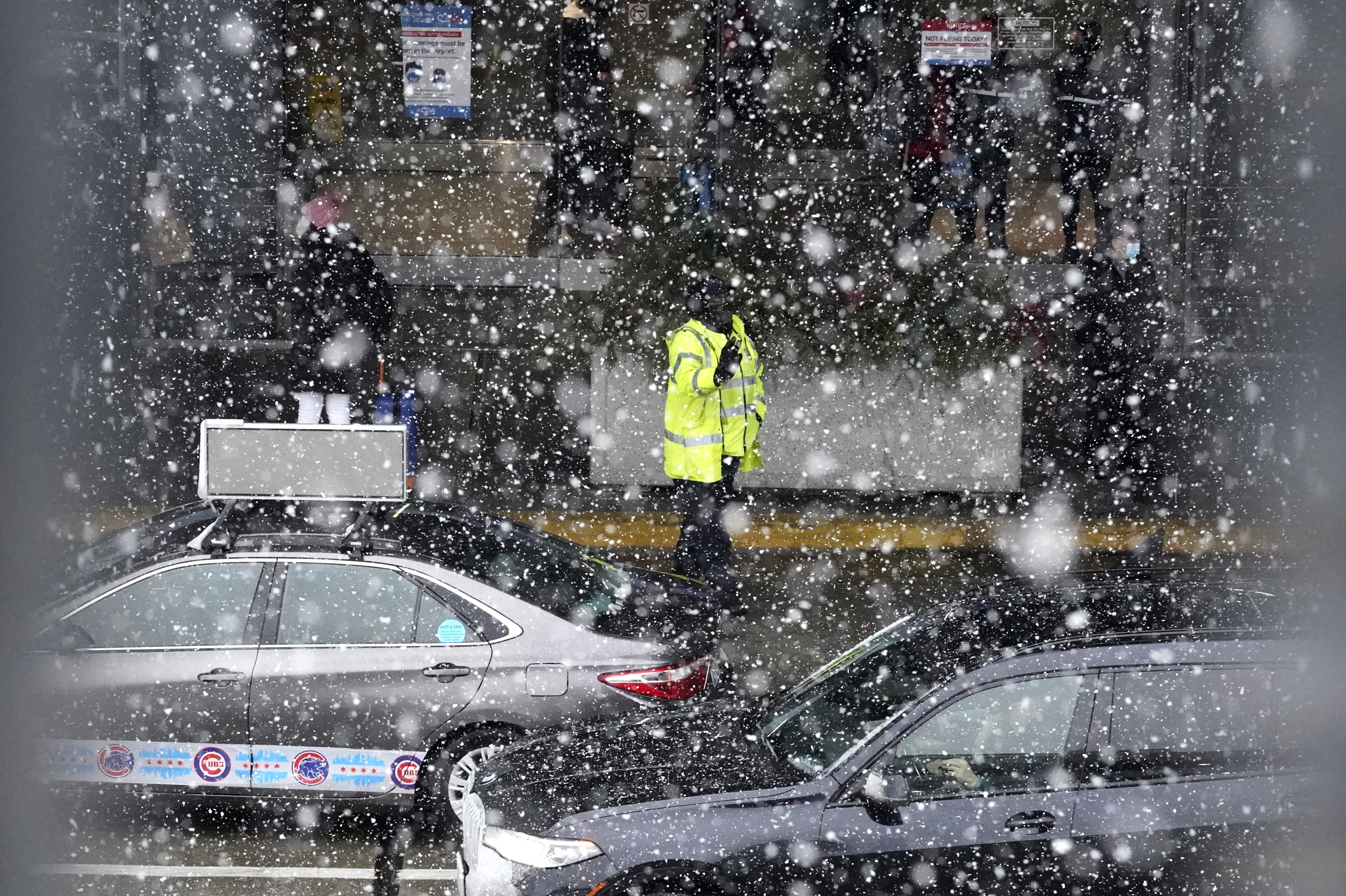 Um funcionário do Aeroporto Internacional O'Hare direciona o tráfego pesado durante um dia de neve em Chicago