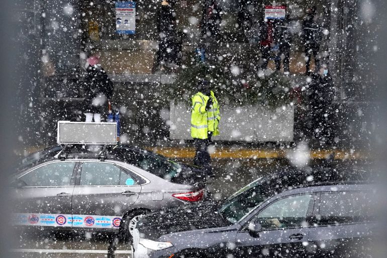 An O'Hare International Airport employee directs heavy traffic during a snowy day in Chicago