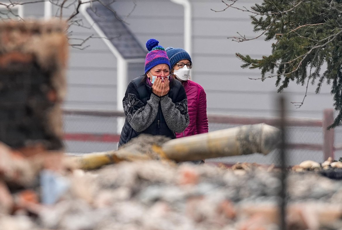 A woman cries as she sees the burned remains of her home destroyed in Colorado