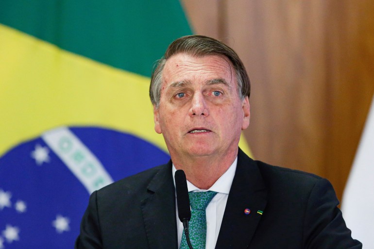 Jair Bolsonaro in front of the Brazilian flag at a press conference