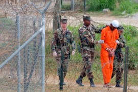 In this Feb. 6, 2002, file photo a detainee is led by military police to be interrogated by military officials at Camp X-Ray at the U.S. Naval Base at Guantanamo Bay, Cuba. At the time the image was taken there were 158 al-Qaida and Taliban