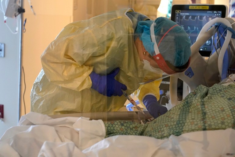 A nurse tends to a patient in the COVID-19 Intensive Care Unit