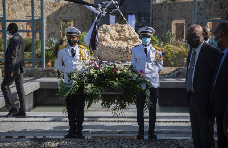 Haitian police officers holding wreath