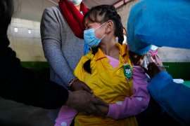 A Nepalese girl receives a dose of the Moderna vaccine for COVID-19 at her school in Kathmandu