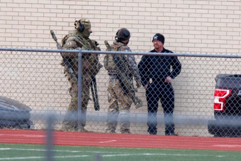 Heavily armed SWAT team members gathered at a local school in response to the hostage situation near the Congregation Beth Israel synagogue in Colleyville, Texas.