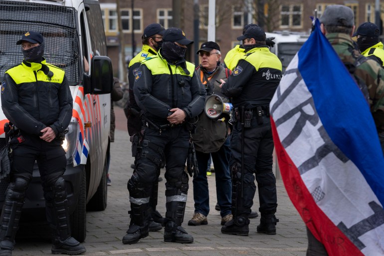 Dutch police arrest a man with a bullhorn as thousands of people gathered to protest against the Dutch government's coronavirus lockdown measures 
