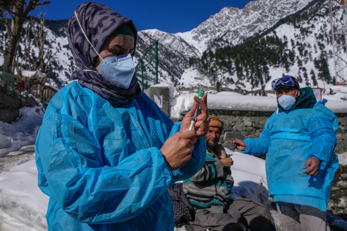 A healthcare worker, prepares a booster dose of the Covishield vaccine in Indian controlled Kashmir