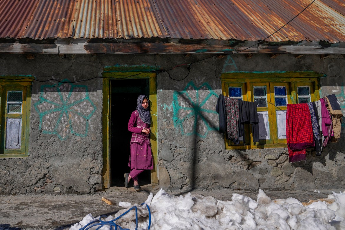 Kashmiri village girl stands at the entrance of her house after receiving the vaccine for COVID-19 in Indian controlled Kashmir