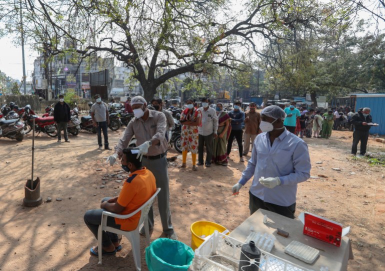 A health worker takes a swab sample of a man to test for COVID-19 in Hyderabad