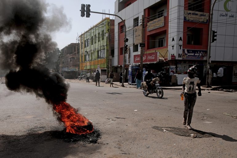 People set up a barricades and burn tires as part of a civil disobedience campaign following the killing of 7 anti-coup demonstrators in Khartoum, Sudan, Tuesday, Jan.18, 2022. The pro-democracy movement condemned Monday's deadly shootings and called for a two-day civil disobedience campaign over the security forces' actions.