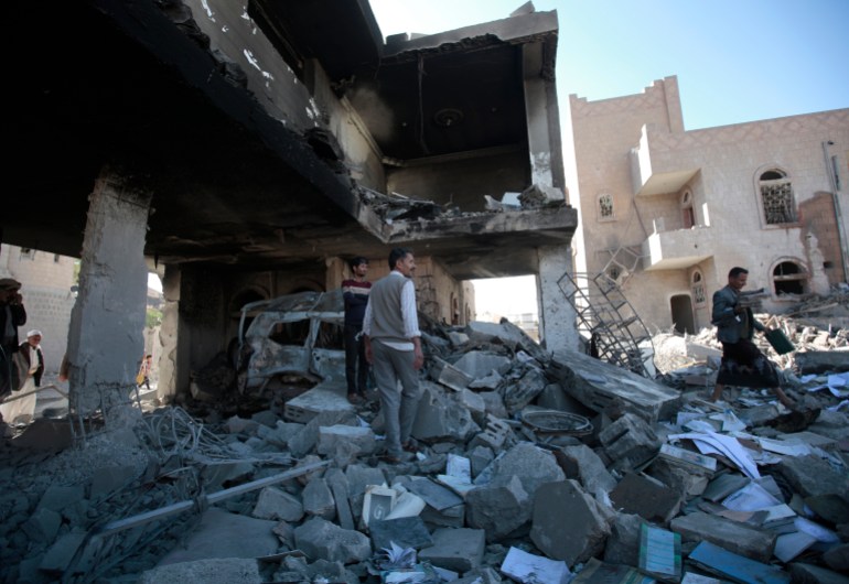 People inspect the remains of buildings damaged by air strikes by the Saudi-led coalition in Sanaa