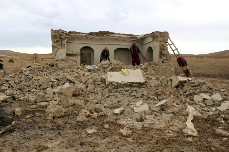 Afghan villagers remove bricks after their home was damaged by earthquake