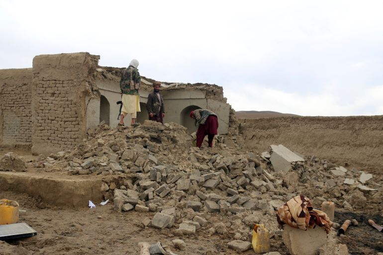 Afghan villagers remove bricks after their home was damaged by earthquake