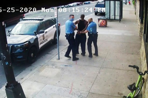 image from video shows Minneapolis police Officers Thomas Lane, left and J. Alexander Kueng, right, escorting George Floyd, center, to a police vehicle outside Cup Foods in Minneapolis.