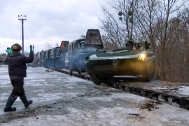 A Russian armoured vehicle drives off a railway platform after arrival in Belarus