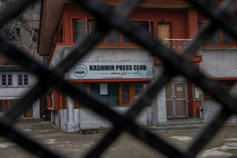 The Kashmir Press Club building is depicted through a closed gate