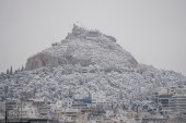 Lycabettus Hill in Athens covered with snow during a snowfall. [Thanassis Stavrakis/AP Photo]