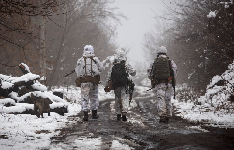 سربازان اوکراینی در خط جدایی از شورشیان طرفدار روسیه در نزدیکی کاترینیوکا در منطقه دونتسک اوکراین قدم می‌زنند.