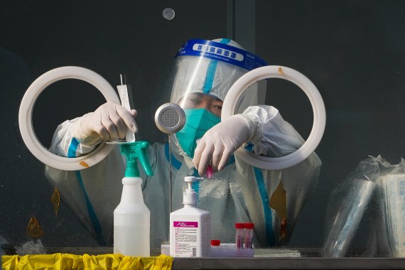 A medical worker wearing protective gear prepares swabs at a coronavirus test site in Xichen District in Beijing, Tuesday, Jan. 25, 2022. Hong Kong has already suspended many overseas flights and requires arrivals be quarantined, similar to mainland China's "zero-tolerance" approach to the virus that has placed millions under lockdowns and mandates mask wearing, rigorous case tracing and mass testing. (AP Photo/Andy Wong)