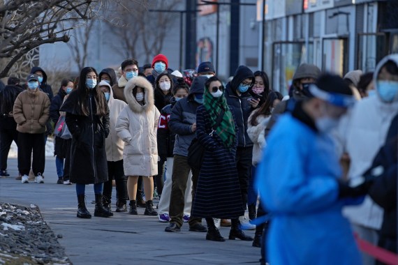 People line up to get a throat swab at a coronavirus test site near a commercial office complex in Beijing, Tuesday, Jan. 25, 2022. Hong Kong has already suspended many overseas flights and requires arrivals be quarantined, similar to mainland China's "zero-tolerance" approach to the virus that has placed millions under lockdowns and mandates mask wearing, rigorous case tracing and mass testing. (AP Photo/Andy Wong)