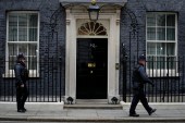 Police officers walk past 10 Downing Street in London [Kirsty Wigglesworth/AP]