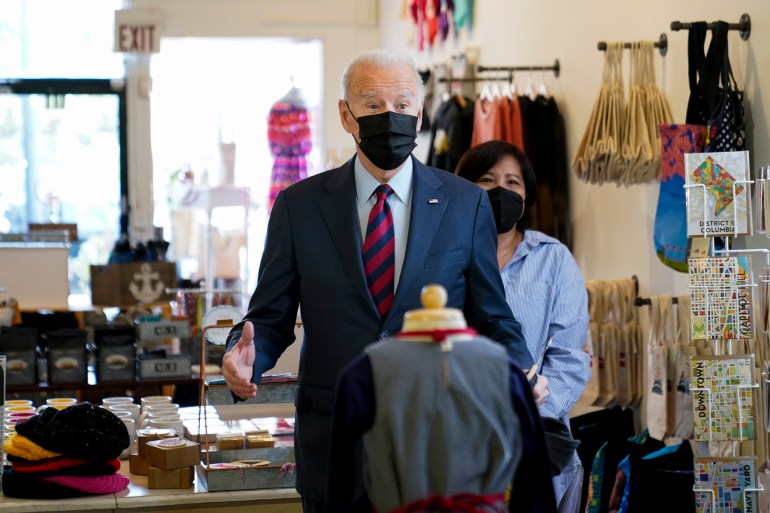 President Joe Biden speaks with members of the media as he visits the local clothing store Honey Made store in Washington