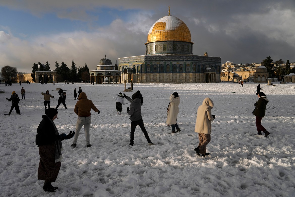 Palestinians enjoy the snow next to the Dome of the Rock Mosque in the Al Aqsa Mosque compound in Jerusalem Old city, Thursday, Jan. 27, 2022. A rare snowfall hit parts of Israel and the West Bank, closing schools and businesses.