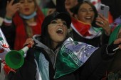 A female Iranian fan cheers after the final whistle during a football match of her national team with Iraq in 2022 World Cup qualifiers [Vahid Salemi/AP]