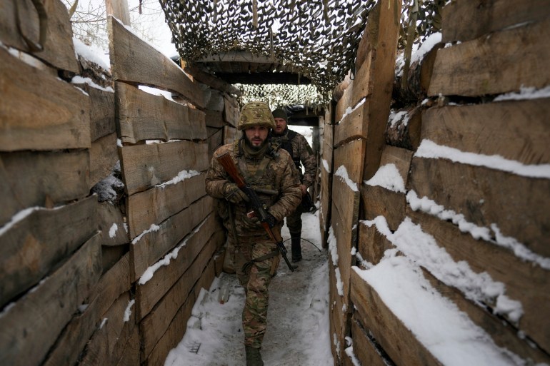 Ukrainian conscripts walk Friday, January 28, 2022 in a ditch on the front line in the Luhansk region, eastern Ukraine.