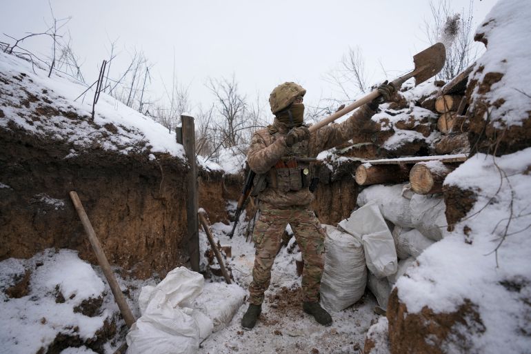 An Ukrainian serviceman cleans his position in a trench on the front line in the Luhansk region, eastern Ukraine, Friday, Jan. 28, 2022.