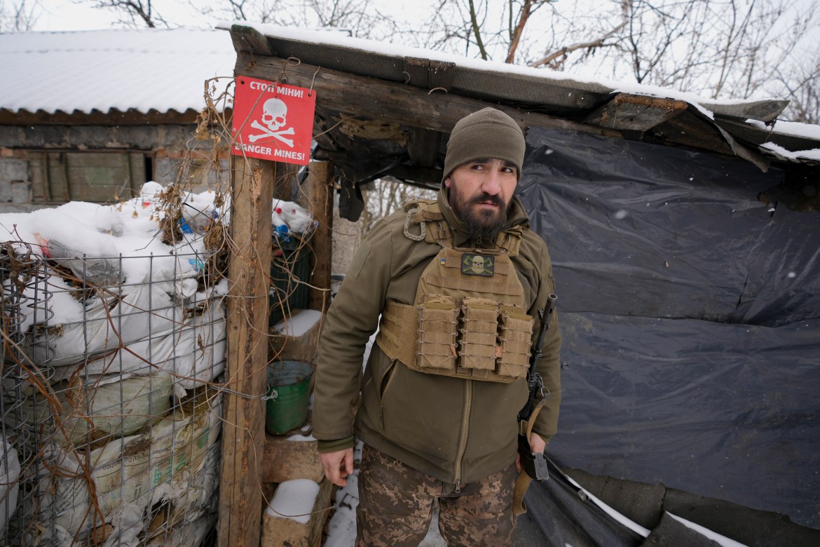 An Ukrainian serviceman looks around as he leaves a shelter on the front line in the Luhansk region, eastern Ukraine, Friday, Jan. 28, 2022.