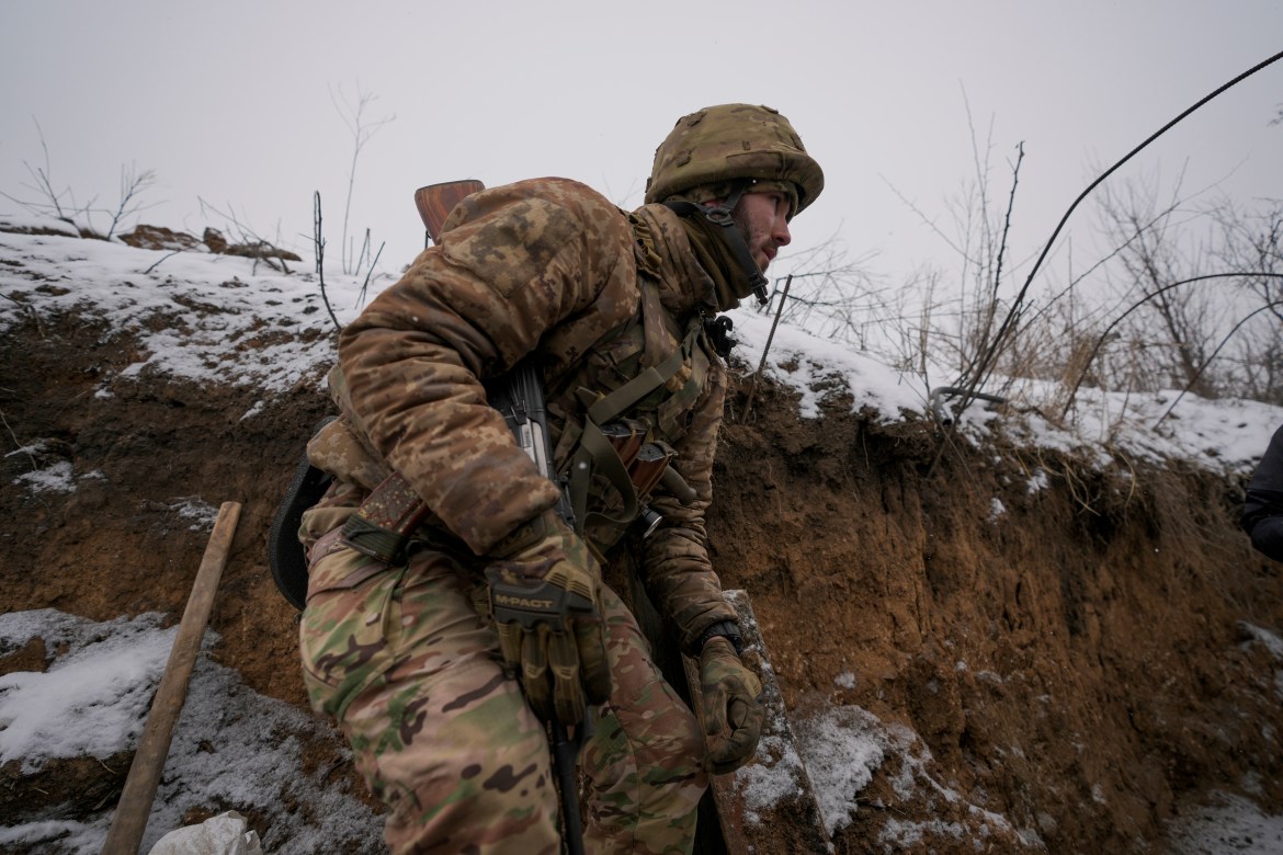 A Ukrainian serviceman ducks in a trench on the front line in the Luhansk region, eastern Ukraine, Friday, Jan. 28, 2022.